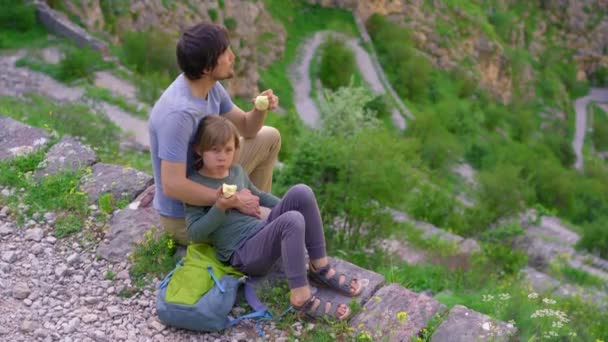 若い男と彼の息子はモンテネグロのコトル市の城の上にハイキングします 古代の岩の道は山の頂上につながります — ストック動画