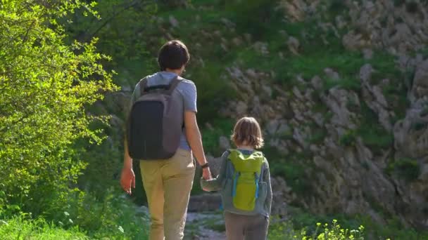 若い男と彼の息子はモンテネグロのコトル市の城の上にハイキングします 古代の岩の道は山の頂上につながります — ストック動画
