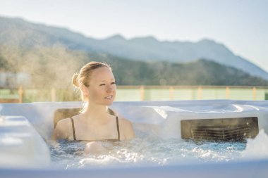 Genç kaygısız mutlu kadının portresi jakuzide rahatlayarak yeşil büyük dağların arka planında mutlu bir tatil hayatı yaşıyor..