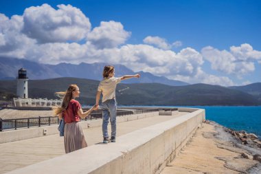 Anne ve oğul turistler Karadağ 'ın Lustica Körfezi' ndeki mimari ve lüks yatların manzarasının keyfini çıkarıyorlar. Karadağ 'da seyahat etmek. Her yere git..