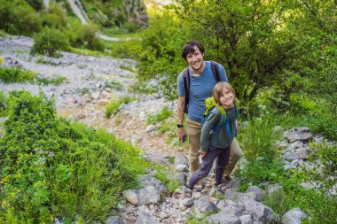 Aile seyahati - baba ve oğul Karadağ 'ın dağlarında yürüyüş yapıyor, Kotor.