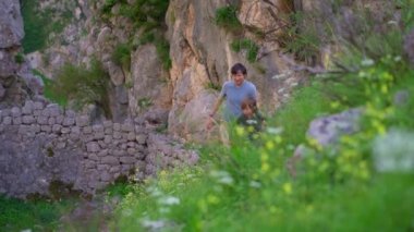 Genç bir adam ve oğlu Karadağ 'ın Kotor kentindeki kalenin tepesine doğru yürüyorlar. Eski kayalık bir yol dağın zirvesine çıkar..