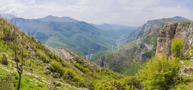 Mavi nehir yeşil vadiden uzak dağlara doğru akıyor. Karadağ 'ın güzel dağları ve Cievna Nehri.