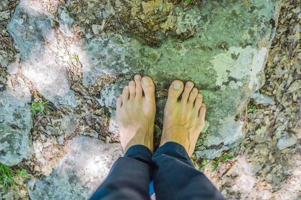 Man tourist climb barefoot the mountain to the Ostrog. It is a tradition to climb barefoot. Monastery of Ostrog, Serbian Orthodox Church situated against a vertical background, high up in the large