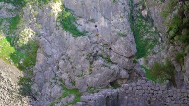 Genç bir adam ve oğlu Karadağ 'ın Kotor kentindeki kalenin tepesine doğru yürüyorlar. Eski kayalık bir yol dağın zirvesine çıkar..