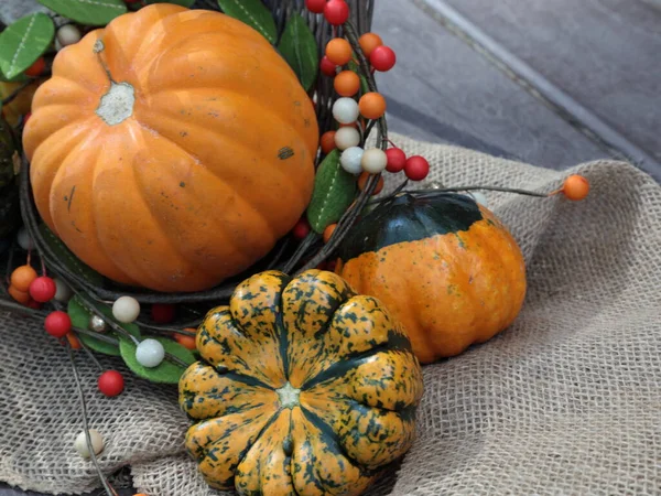 A basket of pumpkins in the fall season with fall decoration.
