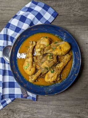 Tahta arka planda bir kase tavuk budu körisi..