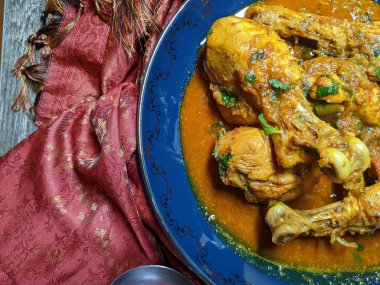 Tahta arka planda bir kase tavuk budu körisi..