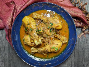 Tahta arka planda bir kase tavuk budu körisi..