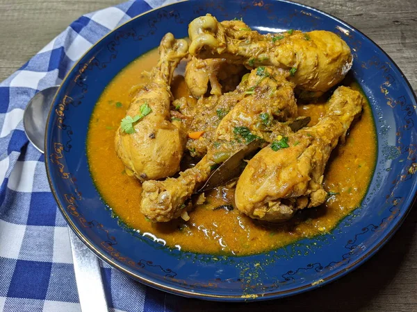 Tahta arka planda bir kase tavuk budu körisi..