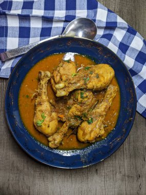 Tahta arka planda bir kase tavuk budu körisi..