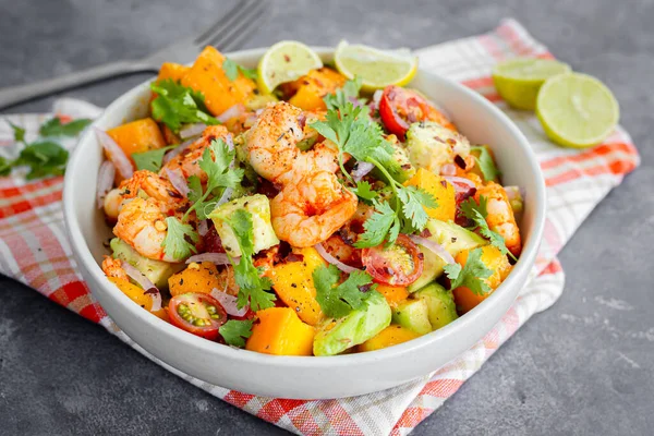 Avokado, kiraz domatesli ve soğanlı sağlıklı karides mango salatası. Taze Cilantro ile süslenmiş.