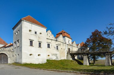 Svirzh Şatosu (XV-XVII yüzyıl), Svirzh, Lviv Oblastı, Ukrayna - 10 Ekim 2021: Svirzh kalesi ve gölet manzaralı sonbahar manzarası, Ukrayna. Güneşli yaprak sonbahar günü. Su birikintileri ve hendeklerin arasında antik bir kale bulunur..