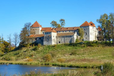 Svirzh Şatosu (XV-XVII yüzyıl), Svirzh, Lviv Oblastı, Ukrayna - 10 Ekim 2021: Svirzh kalesi ve gölet manzaralı sonbahar manzarası, Ukrayna. Güneşli yaprak sonbahar günü. Su birikintileri ve hendeklerin arasında antik bir kale bulunur..