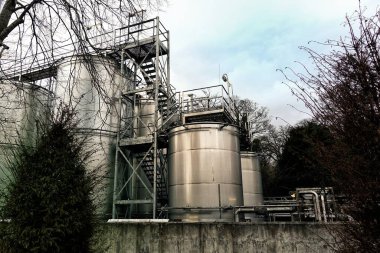 Büyük çelik sanayi fıçıları ya da gaz ya da kimyasallar için konteynırlar, kırsal alanda yürüyüş yolları ve girişleri olan.