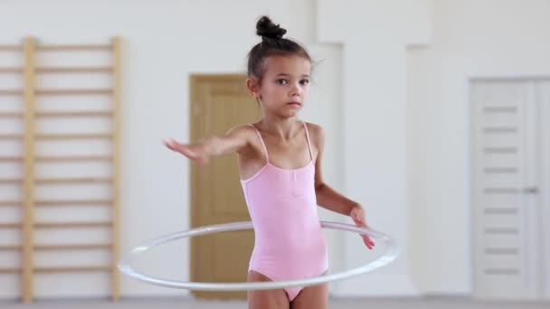 Una pequeña chica acrobática entrenando con un aro en un estudio de ballet — Vídeos de Stock