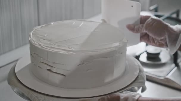 Kvinna kock gör en tårta - jämnar ut grädden på tårtan — Stockvideo