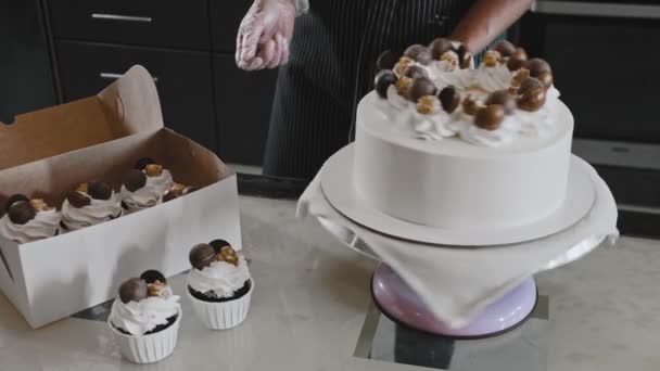 Vrouw chef-kok maken van een taart - tonen versierde taart met witte room — Stockvideo