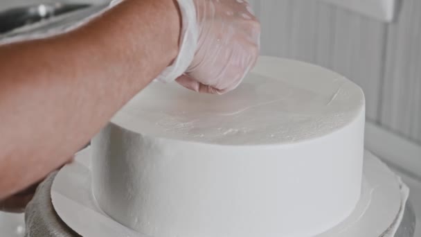 Vrouw chef-kok het maken van een taart - gladstrijkt de witte room op de taart — Stockvideo