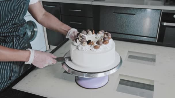 Ein Koch schneidet ein Stück fertigen handgemachten Kuchen aus und nimmt es auf dem Schulterblatt heraus — Stockvideo