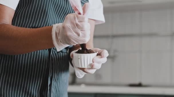 Chef mulher fazendo um bolo - colocando cereja enchimento no saco de pastelaria e aplicá-lo nos cupcakes — Vídeo de Stock