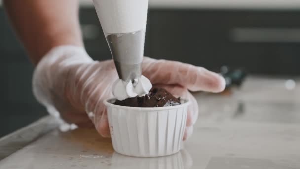 Mujer chef decorando el cupcake con crema blanca dulce — Vídeos de Stock