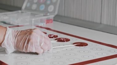 Şef ev yapımı şeker lolipopları yapıyor ve onlara bir değnek veriyor.