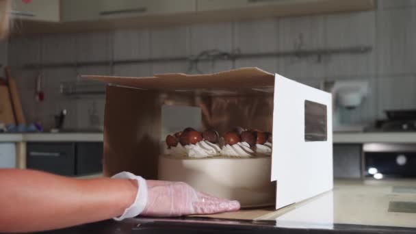 Női séf csomagolás díszített kézzel készített torta egy kartondobozban — Stock videók