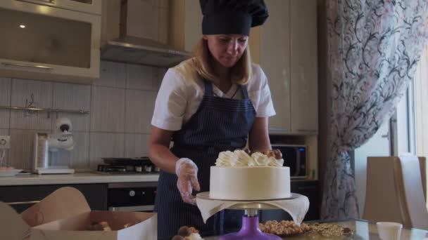Γυναίκα σεφ διακόσμηση λευκό χειροποίητο κέικ με μπάλες σοκολάτας στο πιάτο σερβιρίσματος — Αρχείο Βίντεο