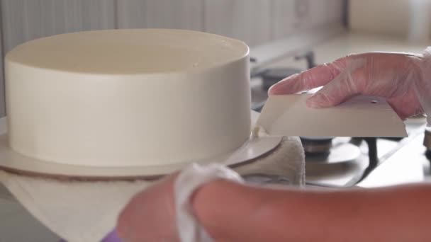 Vrouw chef-kok schoonmaken van de taart crème van de plaat met een schouderblad — Stockvideo