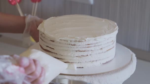Kuchař pokrývající dort s bílou vanilkovou smetanou pomocí pekařské tašky — Stock video