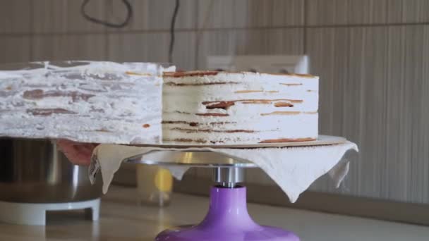 Kobieta szef kuchni zdejmuje plastikową pokrywę z boku tortu — Wideo stockowe