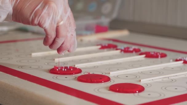 롤리팝 을 만드는 일 - 종 이 위에 붉은 캐러멜 을 뿌리는 일 — 비디오