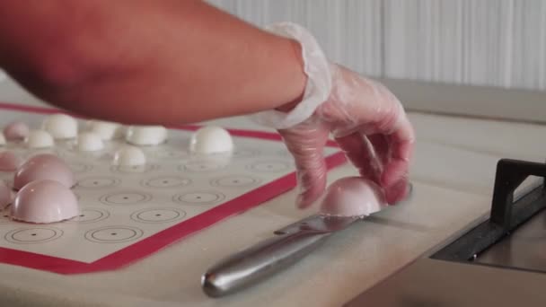 Woman smoothing out the edges of a white cream molds in the white kitchen — Stock Video