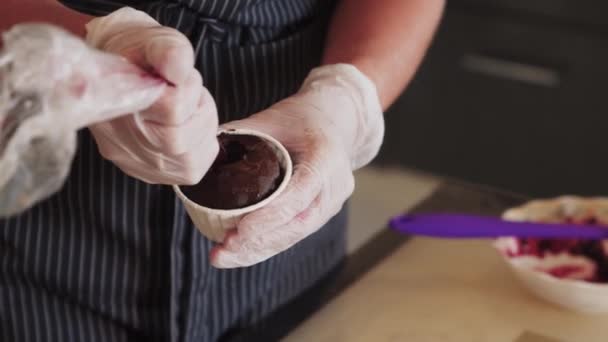 Gieten in de cupcake kersensaus — Stockvideo