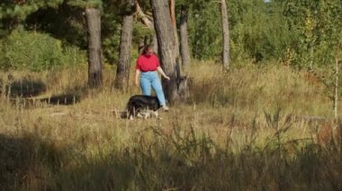 Tombul kadın ve onun tatlı eğitimli büyük köpeği dışarıda birlikte oynuyorlar.