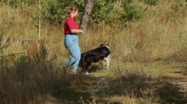 Tombul kadın ve eğitimli büyük köpeği birlikte dışarı çıkıyorlar.
