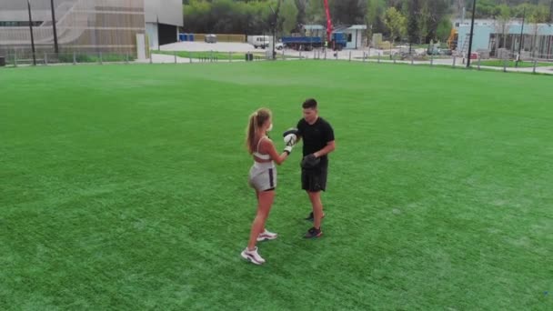Ung kvinna på en boxning utbildning på en grön gräsmatta — Stockvideo
