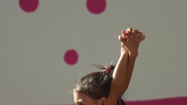 KAZAN, RUSSIA 24-08-21: Spor salonundaki jimnastik sınıfında küçük kız eğitimi - sırtını esnetiyor