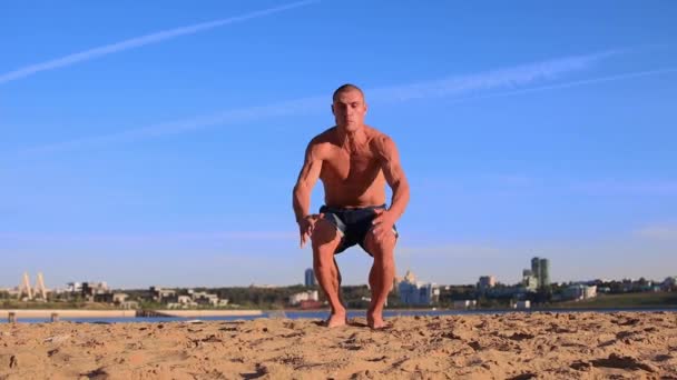 Joven haciendo flexiones en la arena de la playa y realizando volteretas — Vídeos de Stock