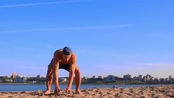 Junger fitter Mann macht an sonnigen Sommertagen Sport am Strand — Stockvideo