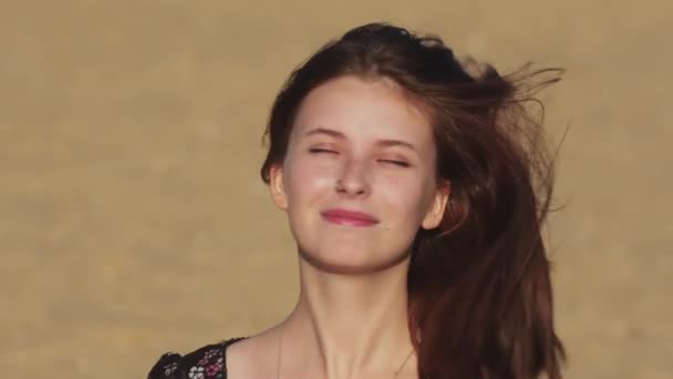 Ung leende kvinna i svart klänning på stranden — Stockvideo