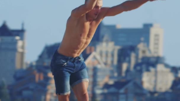 Sportsøvelser udendørs - ung fit akrobatisk mand løber op og laver flips – Stock-video