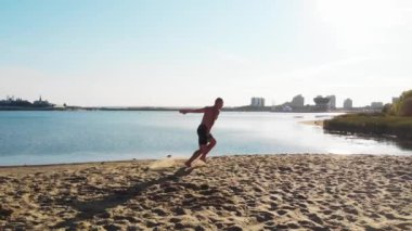 Genç bir adam koşarak şehir plajında taklalar atmaya başladı.
