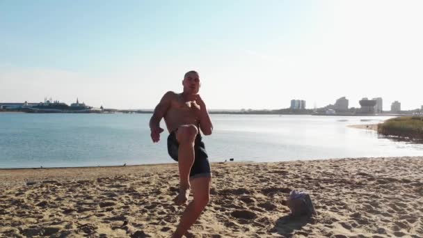Młody mężczyzna wykonuje boks cieni i kopie stopą — Wideo stockowe