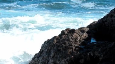 Deniz dalgaları kayalara çarpar