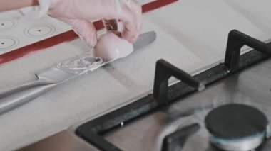 Kadın aşçı krema kalıplarının kenarlarını düzeltiyor.