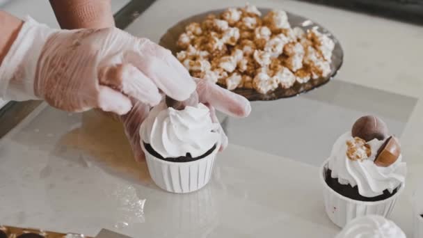 부엌에서 초콜릿 공으로 컵케이크 장식을 하고 있는 요리사 — 비디오
