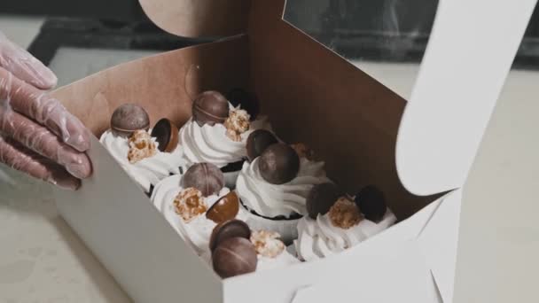 Γυναίκα σεφ έβαλε διακοσμημένα cupcakes στο κουτί από χαρτόνι — Αρχείο Βίντεο