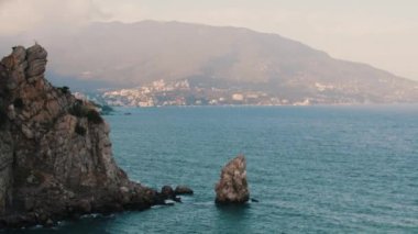 Mavi Deniz büyük kayalara ve kıyı kasabasına ayrılıyor.